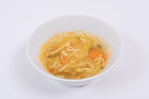 Noodle soup with vegetables on a white background