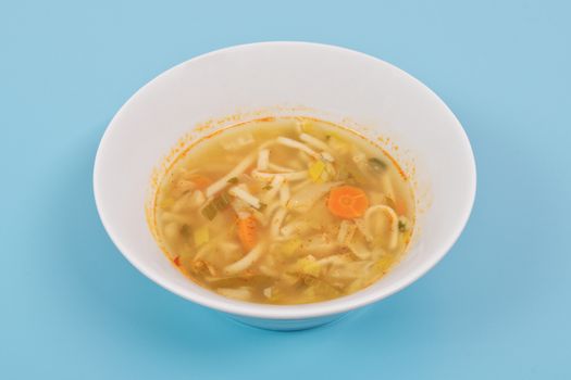 Noodle soup with vegetables on a white background