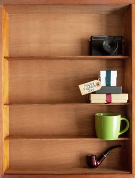 Gift boxes with fathers day label inside a display shelf with coffee cup and pipe