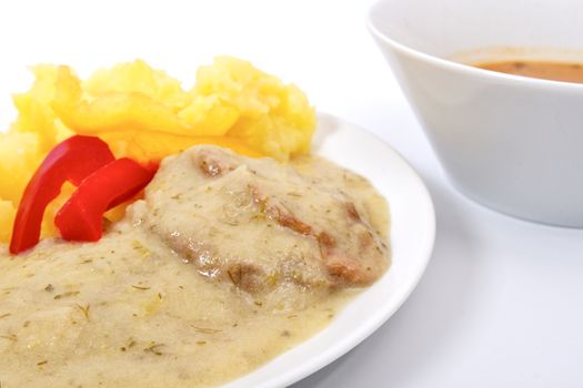 Seitan with dill sauce and potatoes on a white background