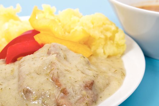 Seitan with dill sauce and potatoes on a blue background