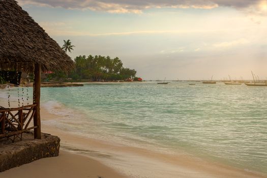 A beautiful beach with Several fishing boats  anchored at sunset with sunbeams.Zanzibar coast,Tanzania.