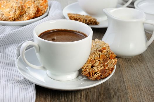 A cup of coffee with gluten-free cookies from cereals on the coffee table. It's time have a bite