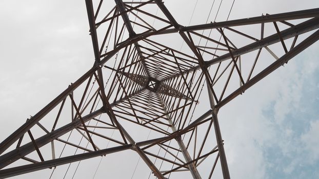 electric high voltage column with wires on the sky background