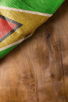 Folded flag of Guyana on a wooden background