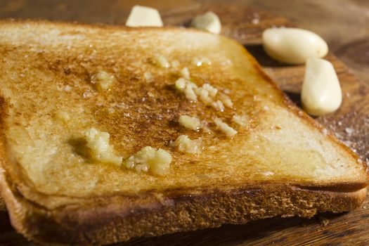 Roasted garlic bread close-up, and cloves of fresh garlic