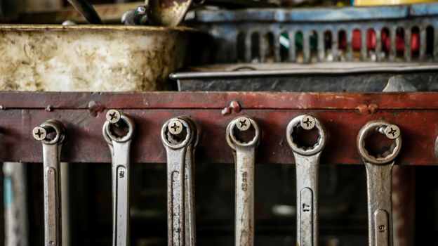 Set of Dirty Wrenches/ Spanners on Wooden Shelf with Different Tools in Garage. Motorbike Repair Shop in  Thailand.