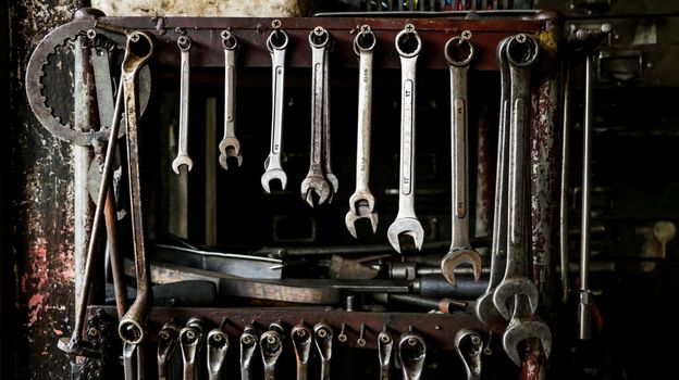 Set of Dirty Wrenches/ Spanners on Wooden Shelf with Different Tools in Garage. Motorbike Repair Shop in  Thailand.