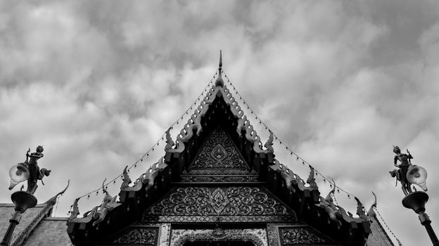 Monochromatic Symmetrical Buddhist Temple Roof in Bangkok Thailand with Beautiful Patterns. Cloudy Sky. High Contrast.
