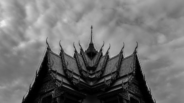 Monochromatic Symmetrical Buddhist Temple Roof in Bangkok Thailand with Beautiful Patterns. Cloudy Sky. High Contrast.