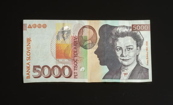 Obsolete 5000 tolar bill of Slovenia, became obsolete with introduction of Euro currency, isolated on black background