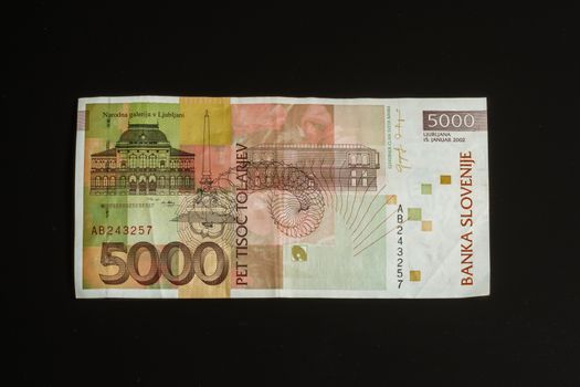 Obsolete 5000 tolar bill of Slovenia, became obsolete with introduction of Euro currency, isolated on black background