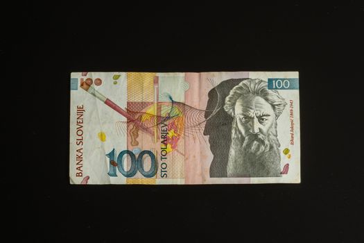 Obsolete 100 tolar bill of Slovenia, became obsolete with introduction of Euro currency, isolated on black background