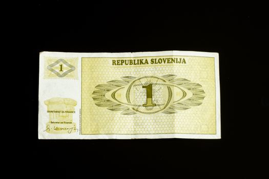 One 1 tolar bill of Slovenia, first paper bank note introduced after declaring independance, isolated on black, when introduced the national currency did not even have a name