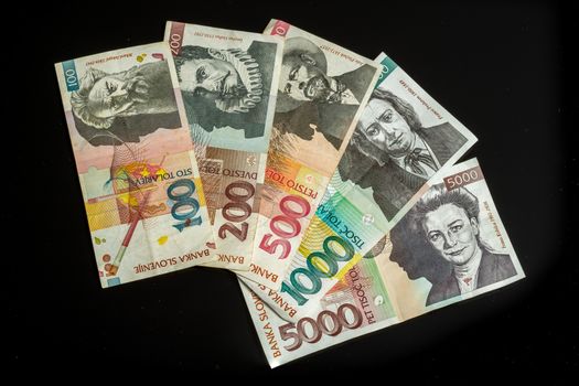 Collection of tolar bills of Slovenia, obsolete currency, no longer in use after introduction of Euro, isolated on black background