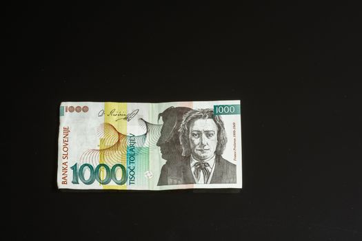 Obsolete 1000 tolar bill of Slovenia, became obsolete with introduction of Euro currency, isolated on black background