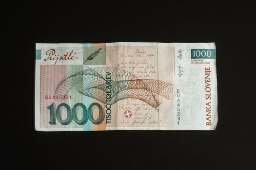 Obsolete 1000 tolar bill of Slovenia, became obsolete with introduction of Euro currency, isolated on black background