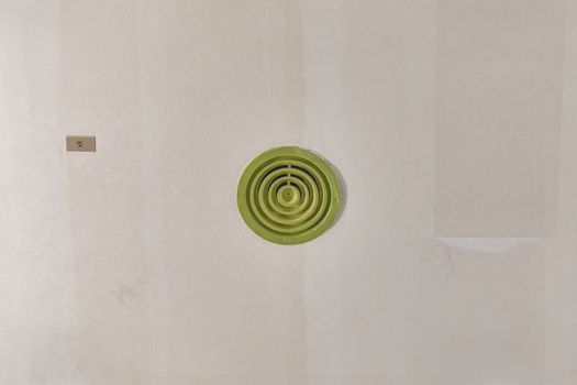 Green round outlet of air condition on ceiling with copy space.