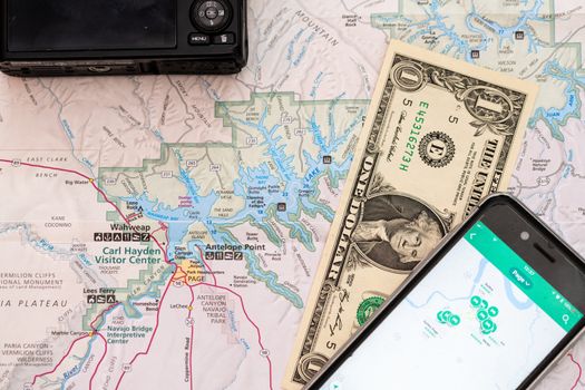 Travel accessories, camera, smart phone one Dollar bill and travel map, detail of Arizona, USA map, travel preparation and planning concept to Lake Powell area