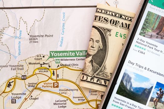 Travel accessories, smart phone, folded one Dollar bill and travel map, detail of Arizona, USA map, travel preparation and planning concept to Lake Powell area