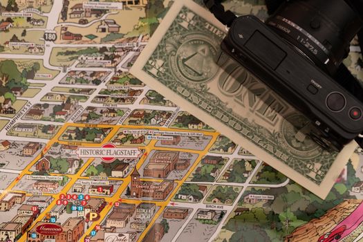 Detail of travel map Flagstaff, Arizona, USA with camera and one Dollar bill, travel planning and preparation concept, Dollar bill just below the couthouse, justice and travel concept