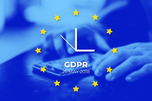 GDPR - General Data Protection Regulation. EU flag with clock, blue photo background. User protects their data on a mobile phone