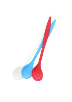 Three empty long plastic spoons - red, blue and white