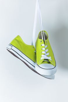 Pair of new green sneakers hanging on the wall