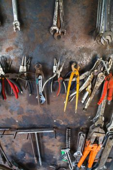 Old tools hanging on metal wall in workshop