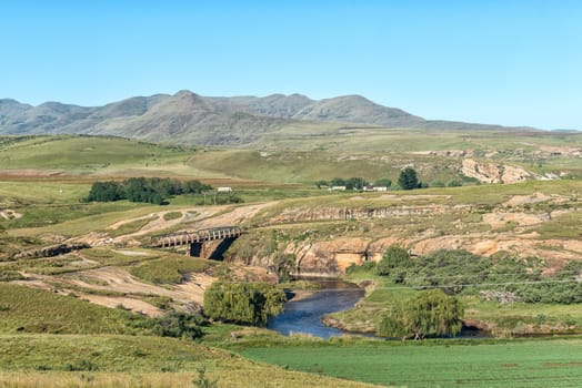 A farm landscape with a single lane bridge on road R396 over the Bell River near Rhodes in the Eastern Cape Province of South Africa
