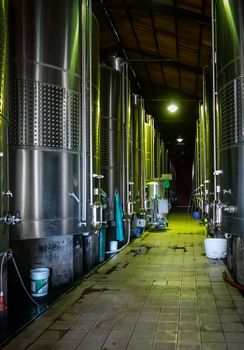 rows of metal wine barrels in a winery