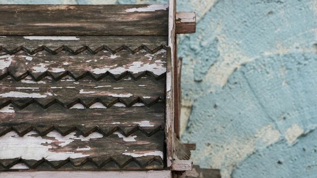 Wooden Roof Pattern with Rough Painted Teal/ Blue Wall - Miniature Wood Temple/ Spirit House in front of Local Home. Rural Thailand.