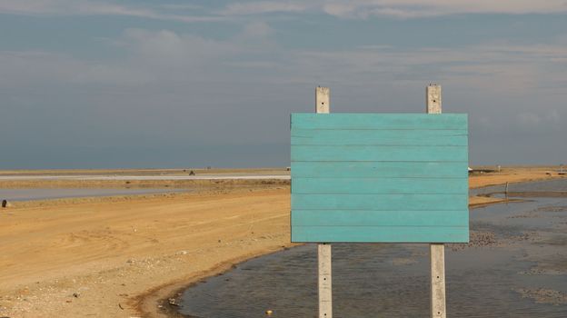 Blank Wooden Sign with Pastel Blue/ Teal Color on Empty Sandy Path - Sea Salt Farm Phetchaburi Thailand. Real Road Sign.