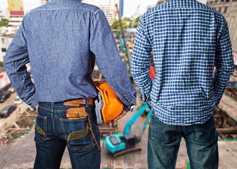 Team of construction workers with orange helmets at workplace on construction site