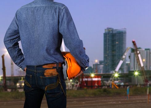 Cropped view of construction worker with orange helmets at workplace on construction site