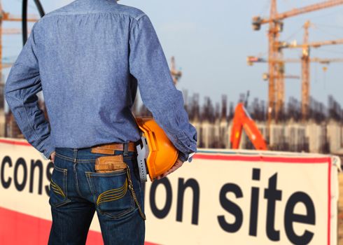 Cropped view of construction worker with orange helmets at workplace on construction site