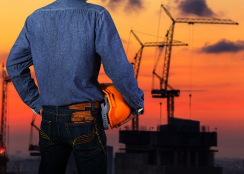 Cropped view of construction worker with orange helmets at workplace on construction site