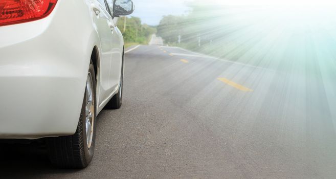 Close up side of white car and light on asphalt road