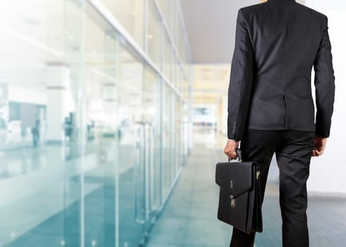 Businessman holding a briefcase in a modern office