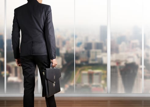 Businessman holding a briefcase in a modern office