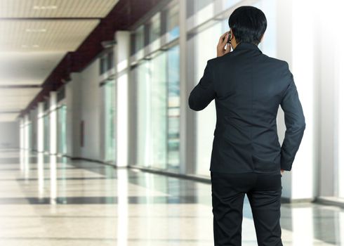 Attractive businessman using a cellphone on a modern office