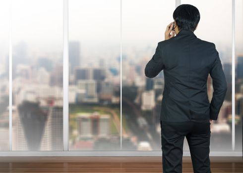 Attractive businessman using a cellphone on a modern office