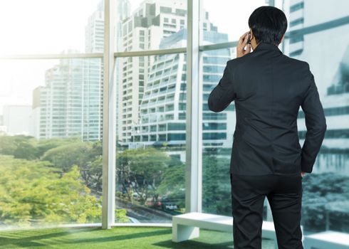 Attractive businessman using a cellphone on a modern office