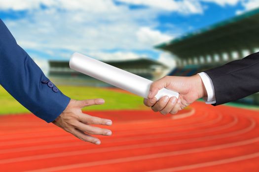 Cropped hand of businessman passing relay baton to colleague, the concept of teamwork for business success