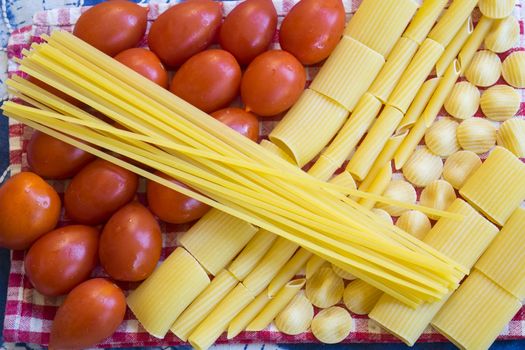 raw assorted pasta with fresh ripe tomatoes 