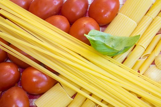 raw assorted pasta with fresh tomatoes and basil