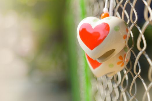 Heart toys on the cage metal net background