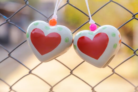 Heart toys on the cage metal net background