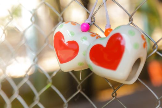 Heart toys on the cage metal net background