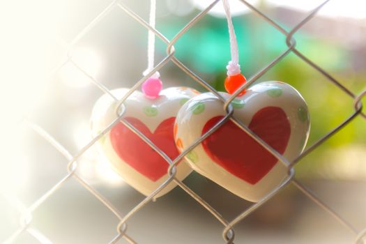 Heart toys on the cage metal net background